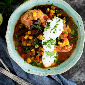 slow cooker mexican chicken in a bowl topped with cilantro and sour cream