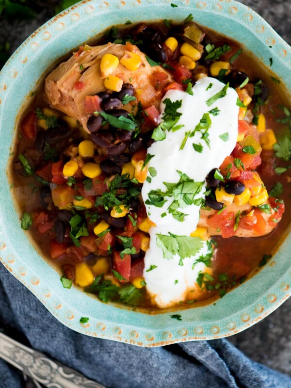 slow cooker mexican chicken in a bowl topped with cilantro and sour cream