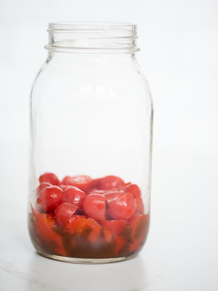 balsamic vinaigrette, roasted peppers, and grape tomatoes in a jar