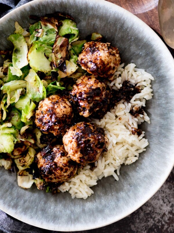 sticky sweet chicken meatballs in a bowl with rice and brussels sprouts
