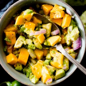 avocado mango salsa in a bowl being spooned out