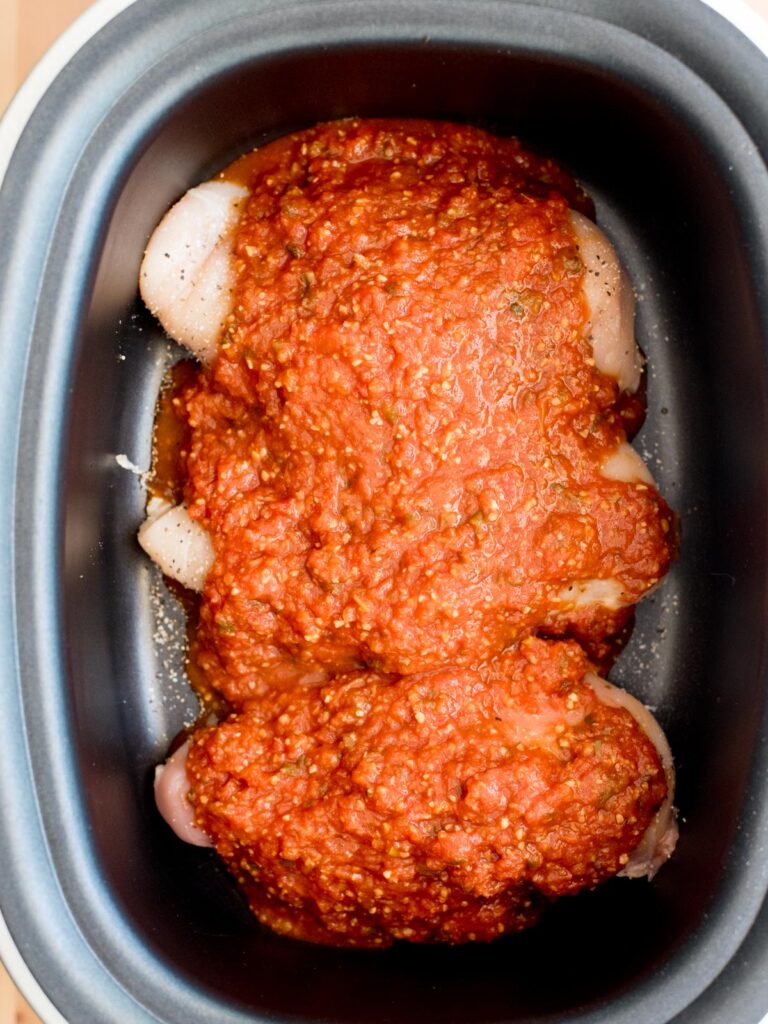 seasoned chicken with salsa in crockpot sleeve