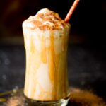 pumpkin milkshake in a glass with a caramel drizzle