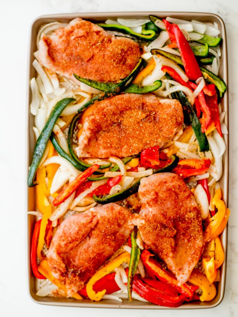seasoned chicken added to the sheet pan