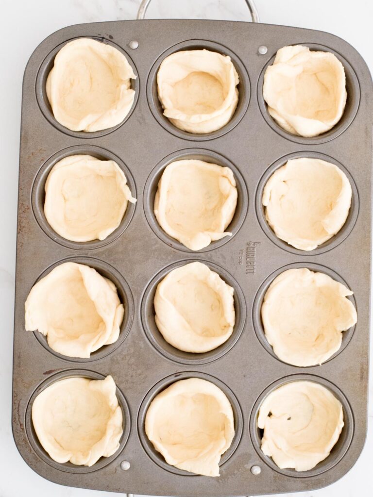crescent roll dough in a muffin tin