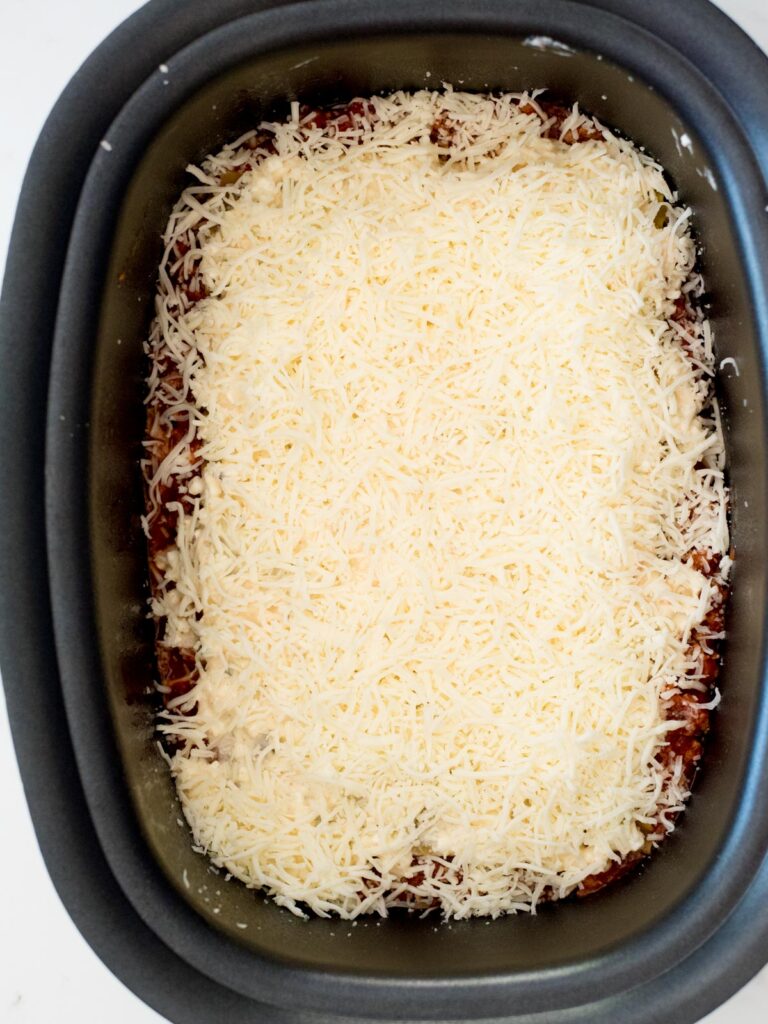 shredded mozzarella over cheese mix in crockpot