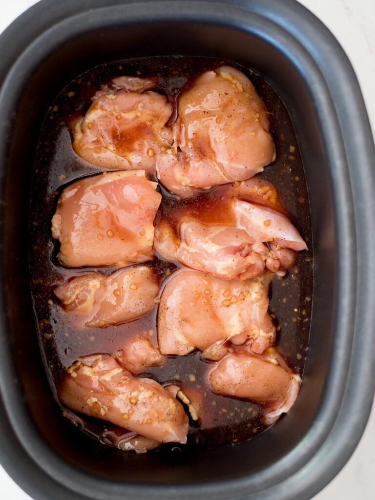 chicken thighs covered in honey garlic sauce in a crockpot
