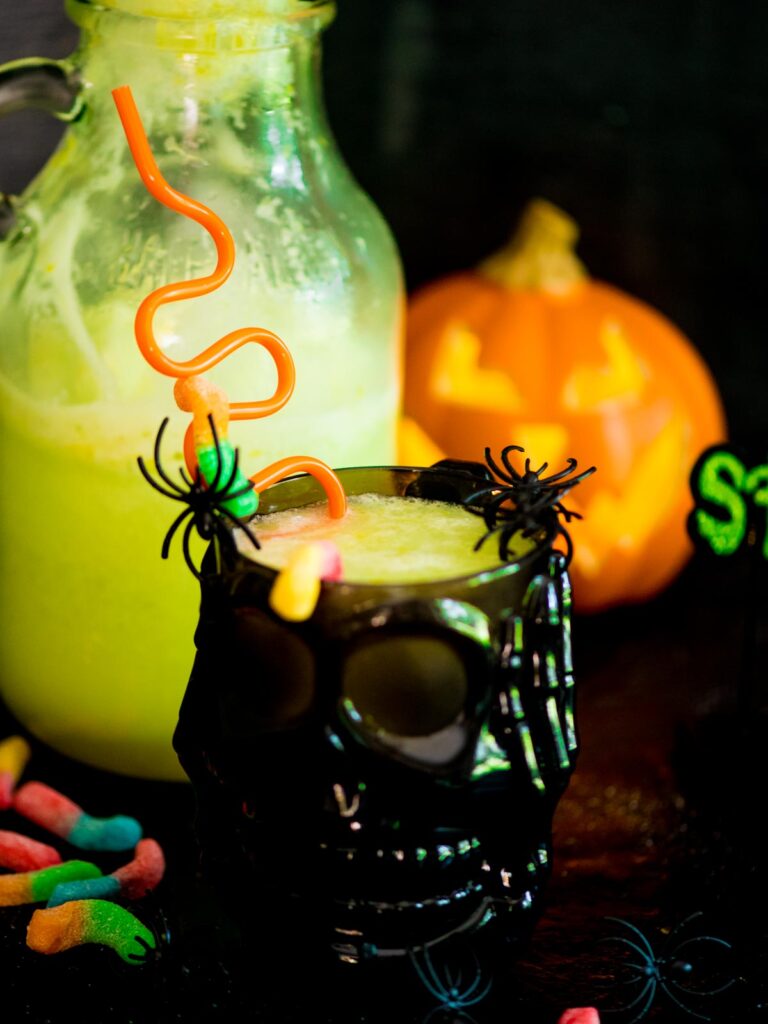 bug juice drink in a skull cup with plastic spiders and gummy worms