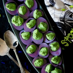 purple and green deviled eggs on a platter