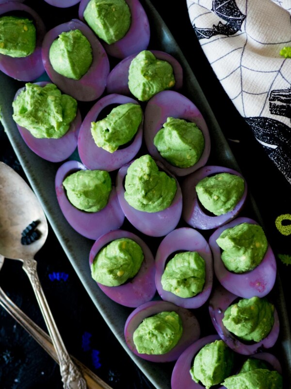 purple and green deviled eggs on a platter