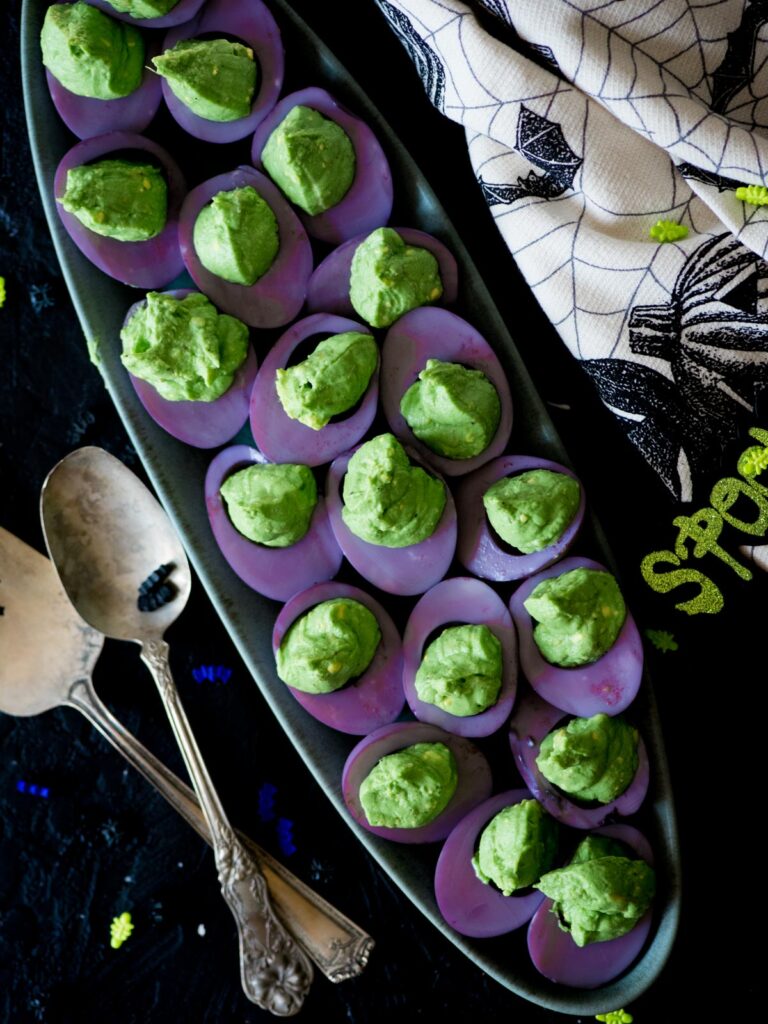 halloween deviled eggs on a platter with serving ware