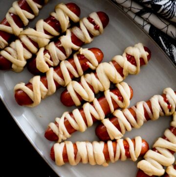 mummy pigs in a blanket on a serving tray