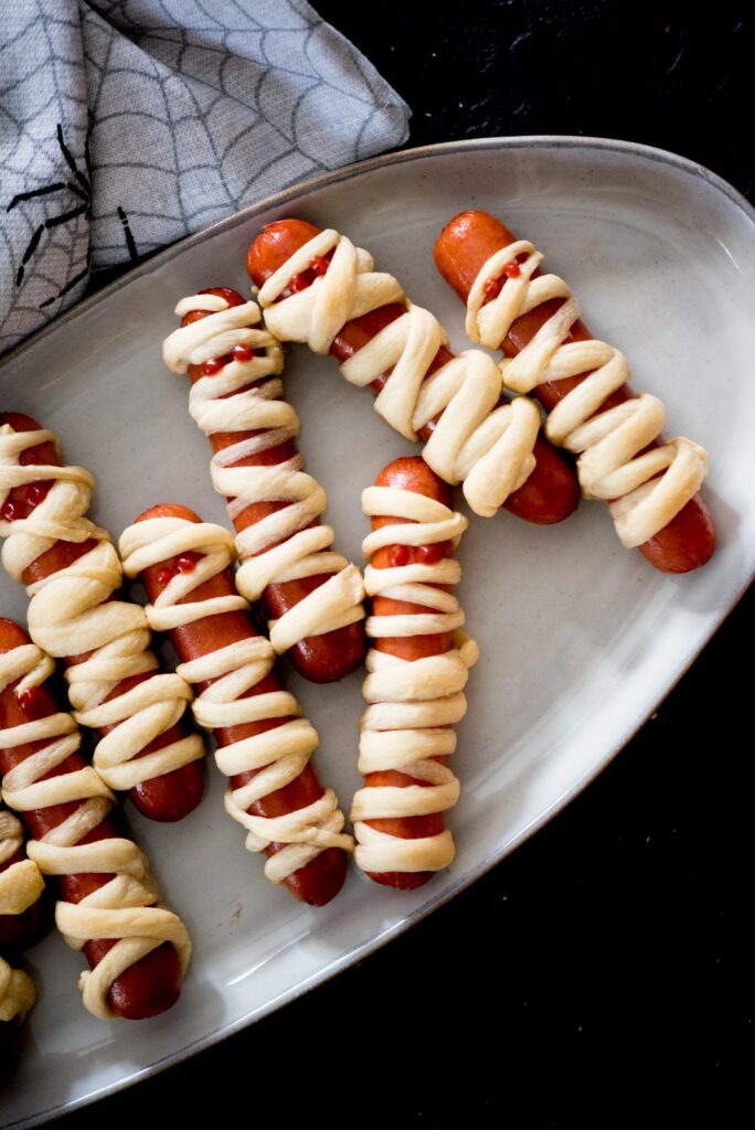 mummy pigs in a blanket on a serving tray