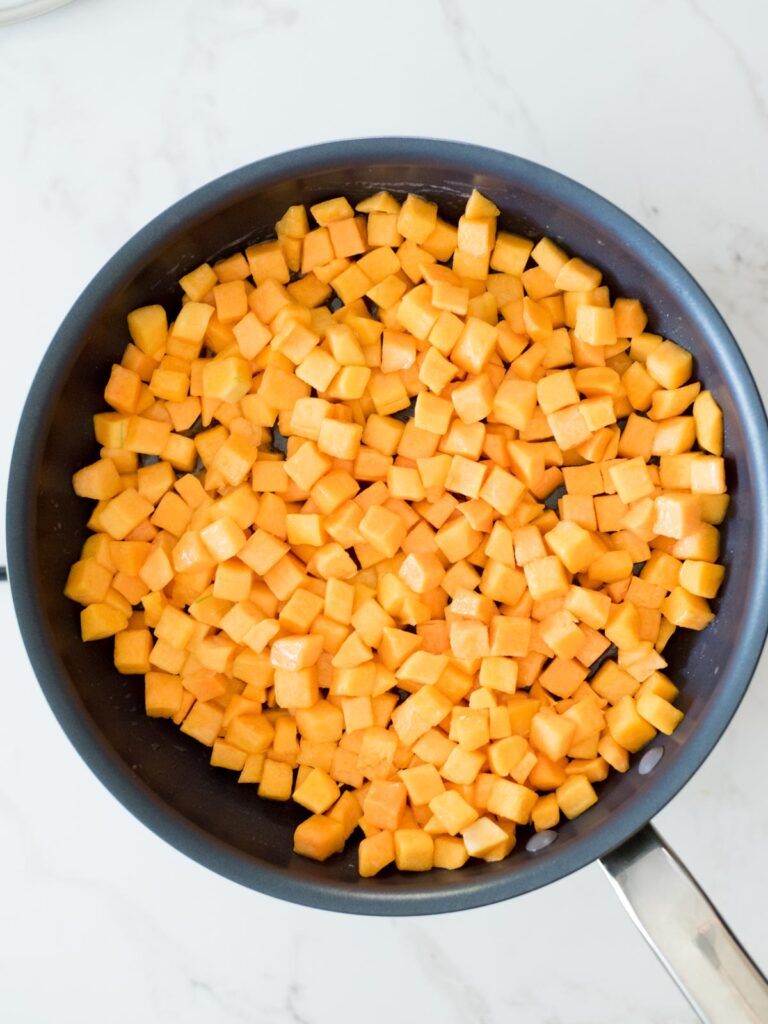 butternut squash mixed with melted butter in a skillet