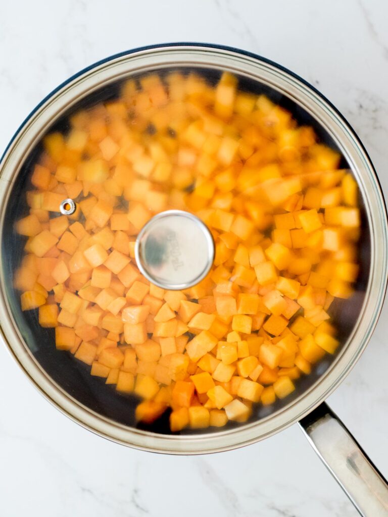 lid placed on skillet with butternut squash and butter