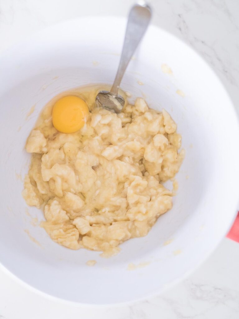 egg with mashed bananas in a mixing bowl