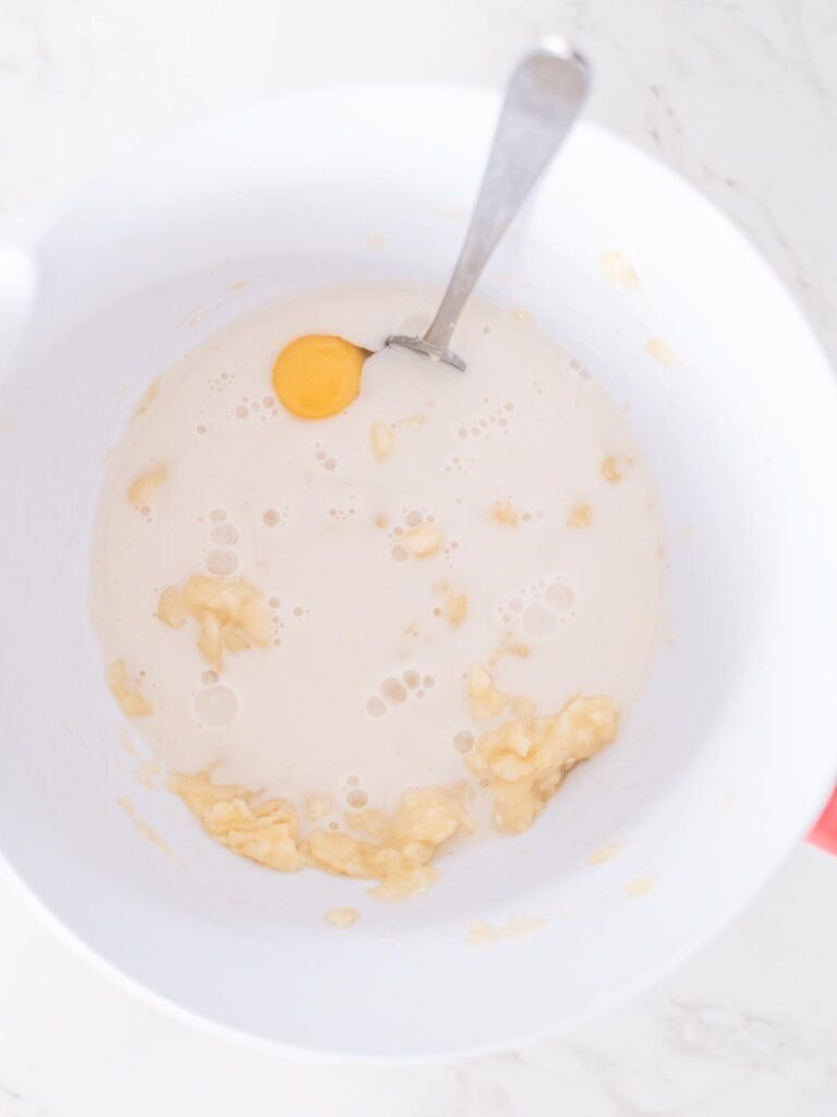 almond milk added to the bananas and egg in a mixing bowl