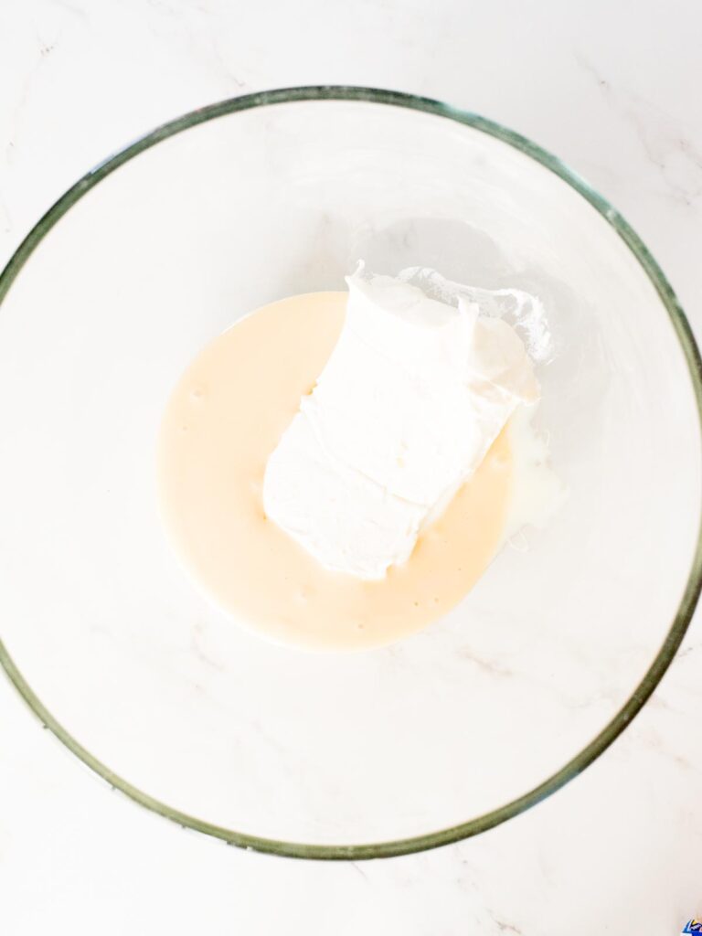 cream cheese and eagle brand condensed milk in a mixing bowl