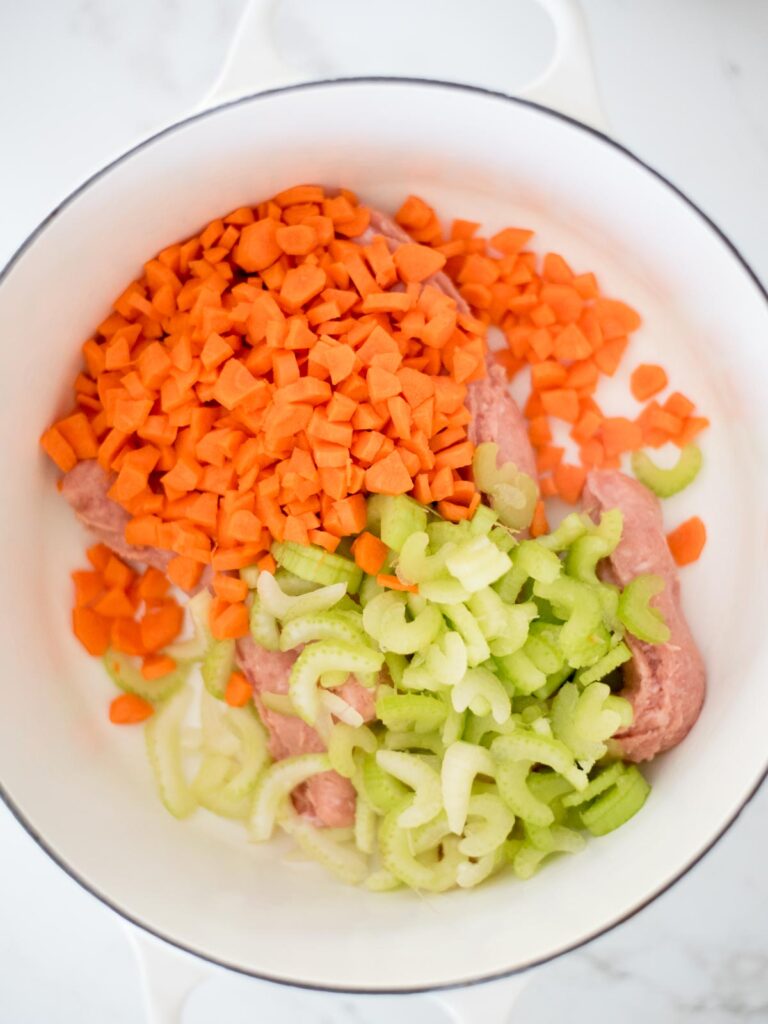 carrots and celery added to italian sausage in the dutch oven