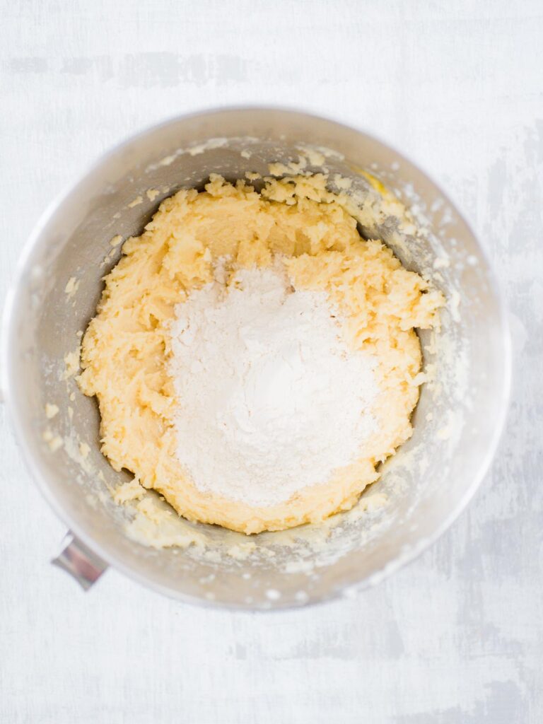 dry ingredients added to the creamed butter and sugar in a mixing bowl for sugar cookies