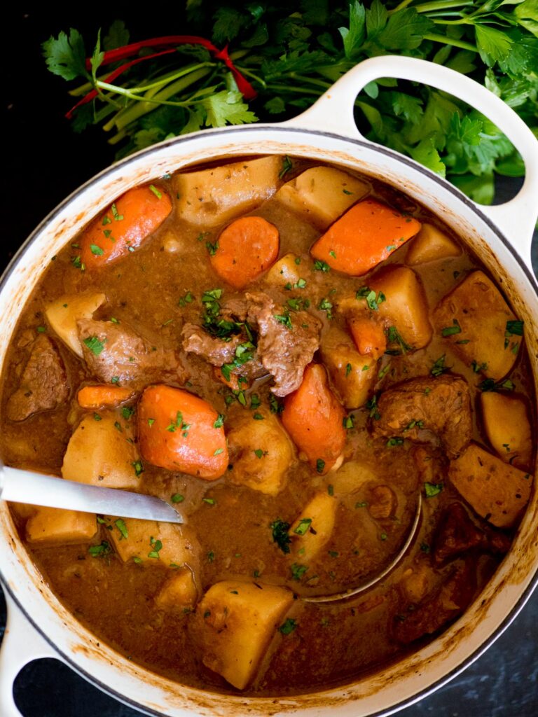 simple beef stew recipe in a dutch oven topped with parsley