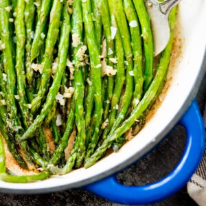 asparagus with butter and garlic in an enamel coated cast iron skillet