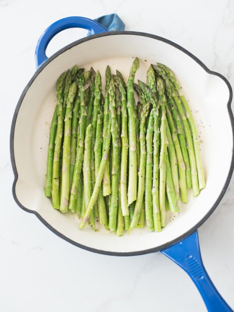 seasoned asparagus in a cast iron skillet