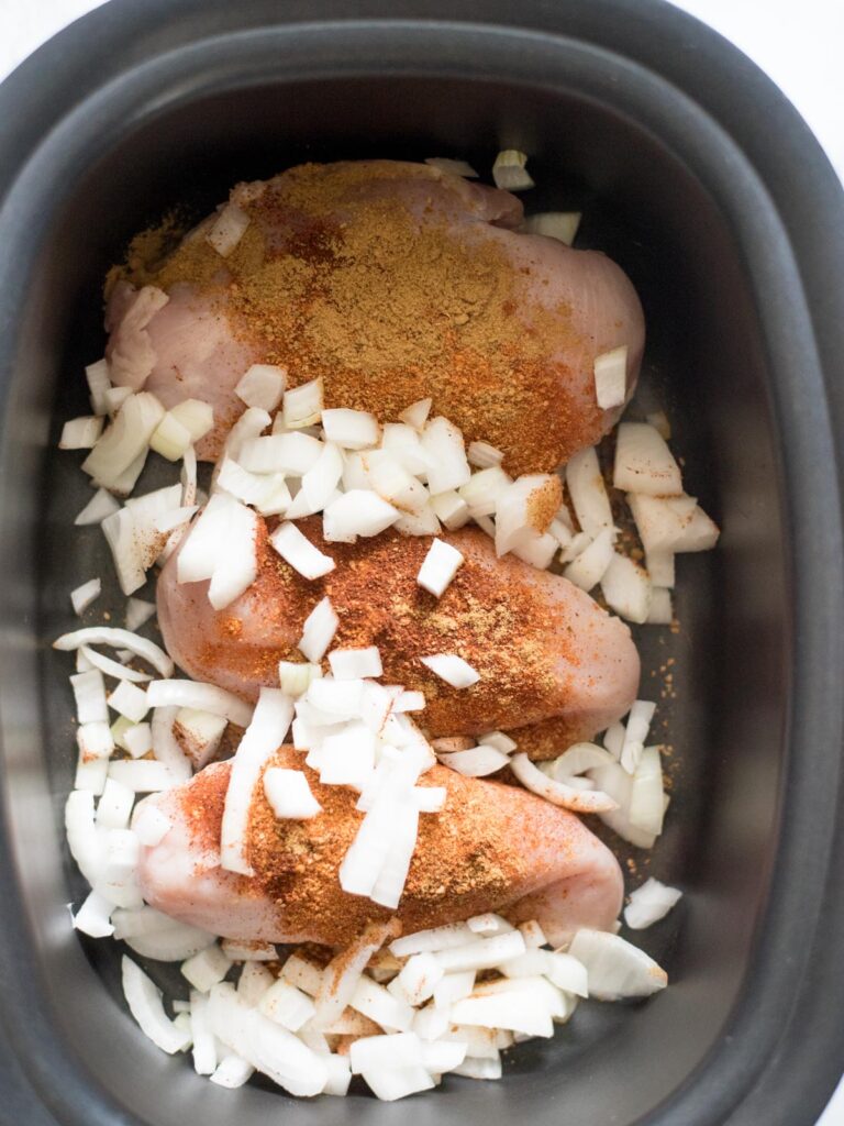 onions and seasoned chicken in a crockpot