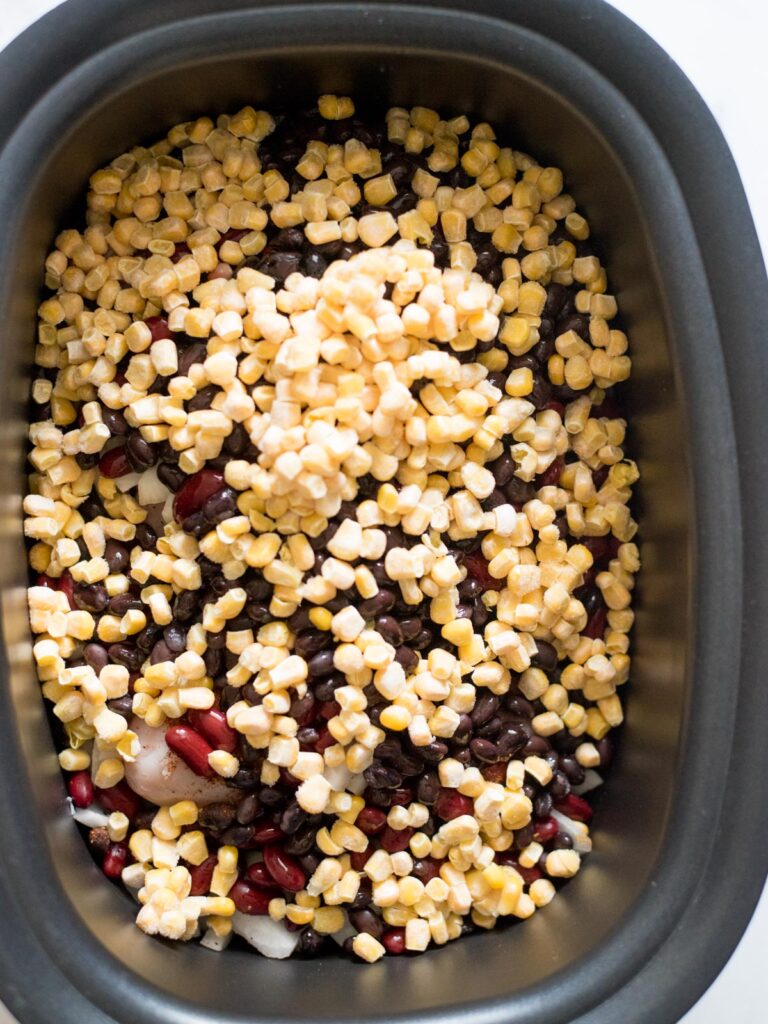corn added to beans in a crockpot