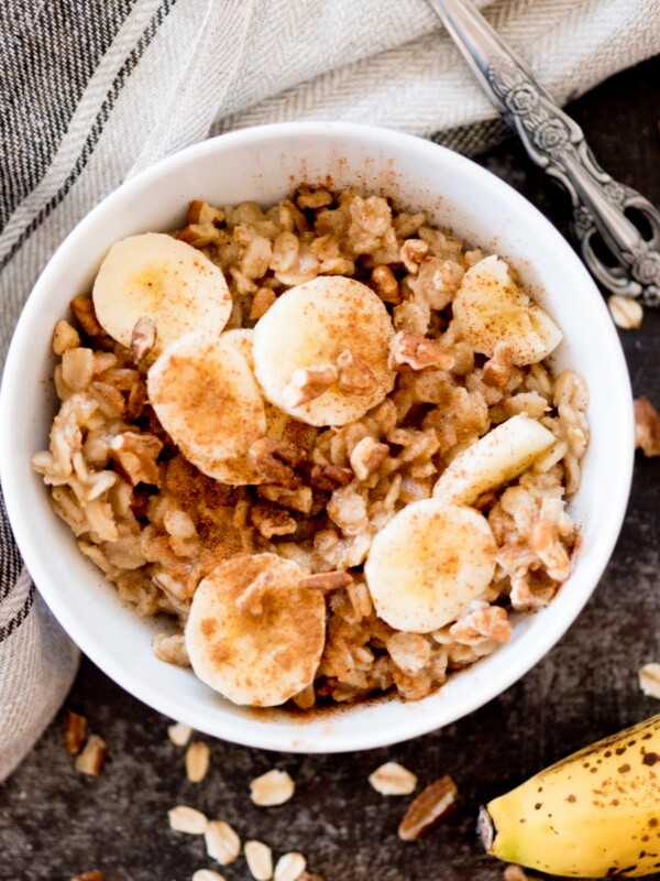 banana oatmeal in a bowl topped with cinnamon and nuts