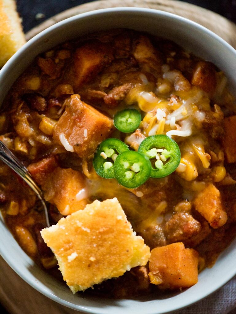 crockpot chicken chili topped with cornbread and jalapeno slices