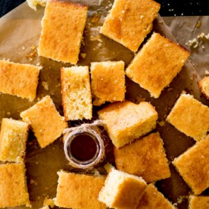 cornbread recipe cut into squares with honey drizzled