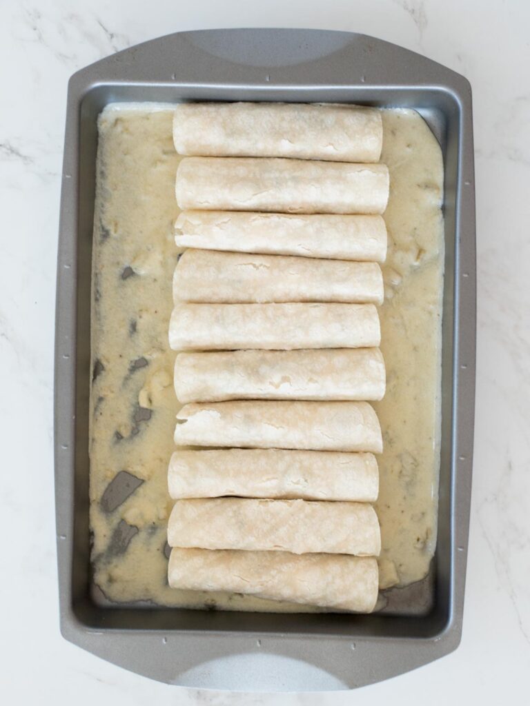 filled and rolled enchiladas in a pan