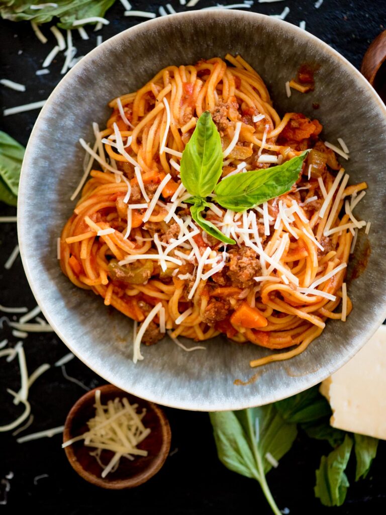 instant pot spaghetti topped with fresh basil and shredded parmesan