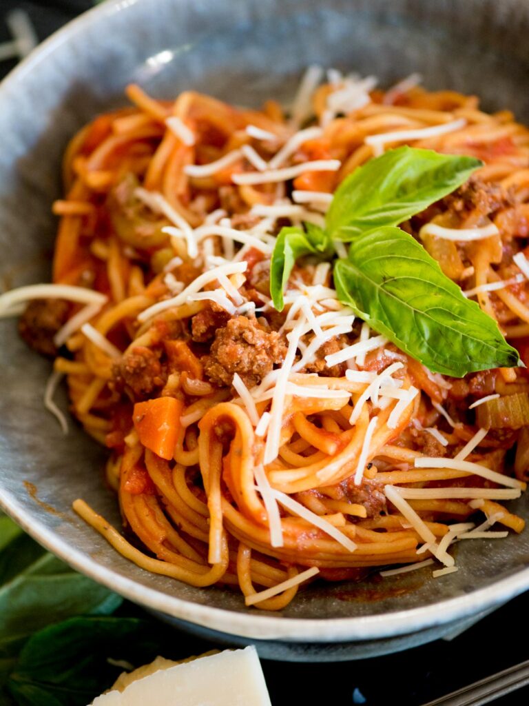 instant pot spaghetti with meat sauce in a bowl topped with basil and parmesan
