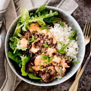 korean ground beef bowl topped with spicy mayo and sesame seeds