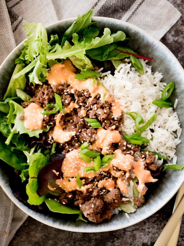 korean ground beef bowl topped with spicy mayo and sesame seeds