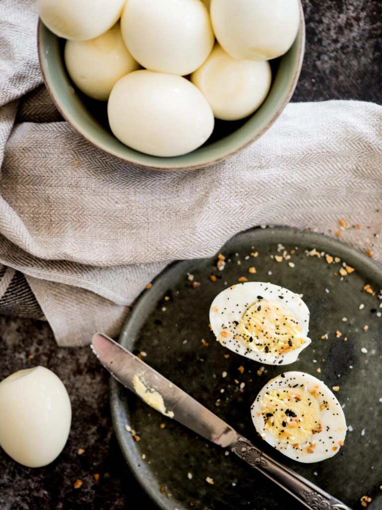 instant pot hard boiled eggs in a bowl with a sliced egg seasoned with everything seasoning