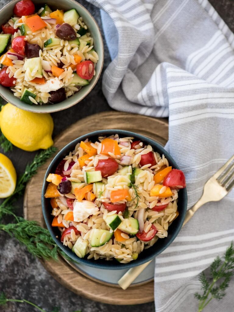 orzo pasta salad in a bowl topped with fresh dill