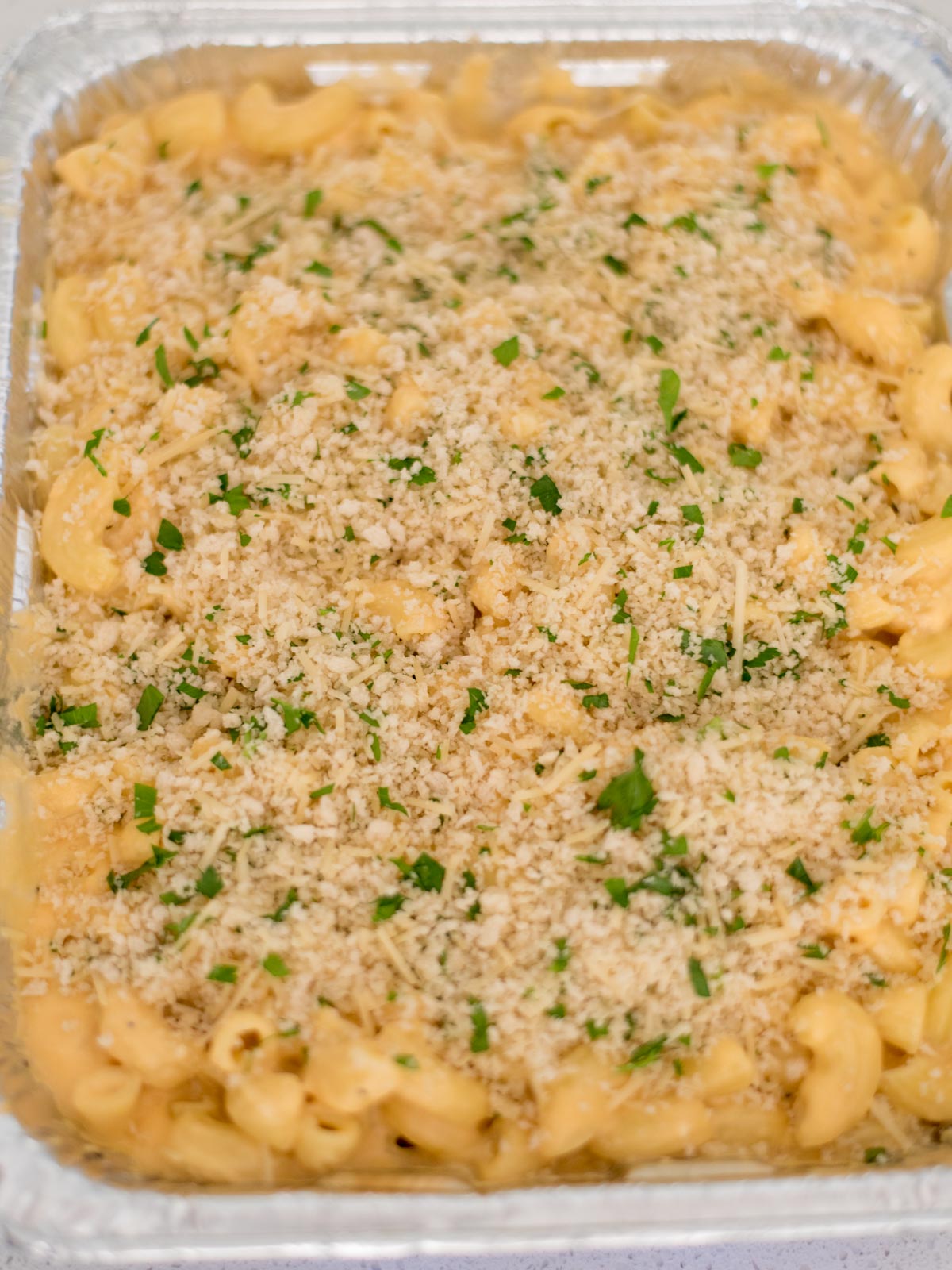 breadcrumb mixture added to the top of the macaroni and cheese sauce