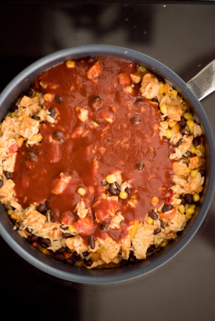 Enchilada sauce added to the skillet with the cooked southwest chicken and rice skillet.