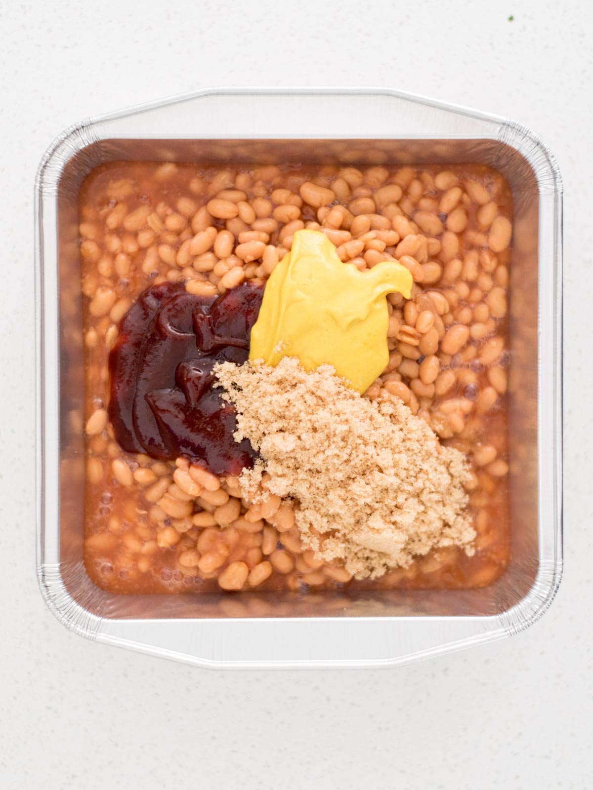 ingredients to make smoked baked beans together in a container