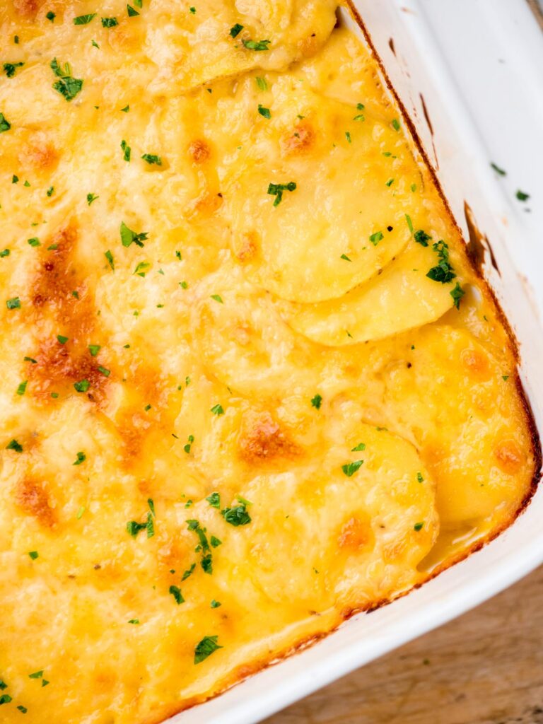 Cheesy au gratin potatoes ready to serve in a baking dish.