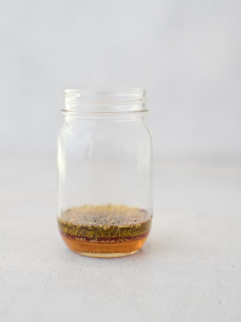 Mason jar with dressing in the bottom.