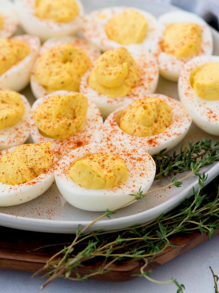 Tray of deviled eggs ready to serve with paprika sprinkled over the top.