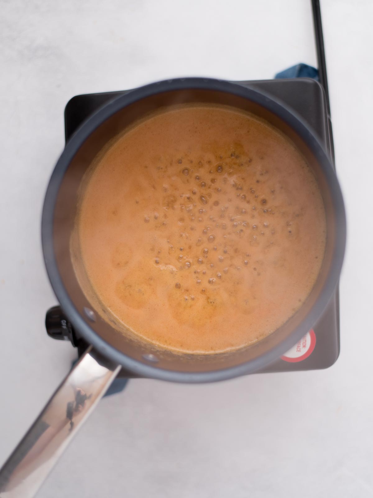 garlic butter wing sauce simmering in a saucepan