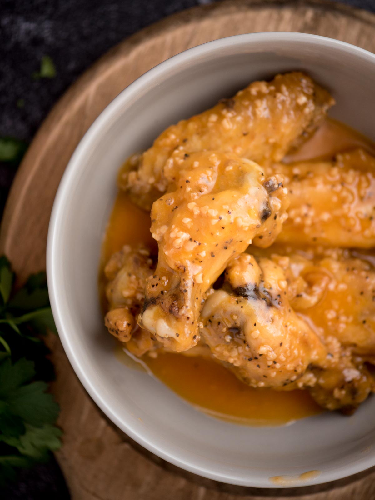 garlic butter wings coated in a sauce in a bowl