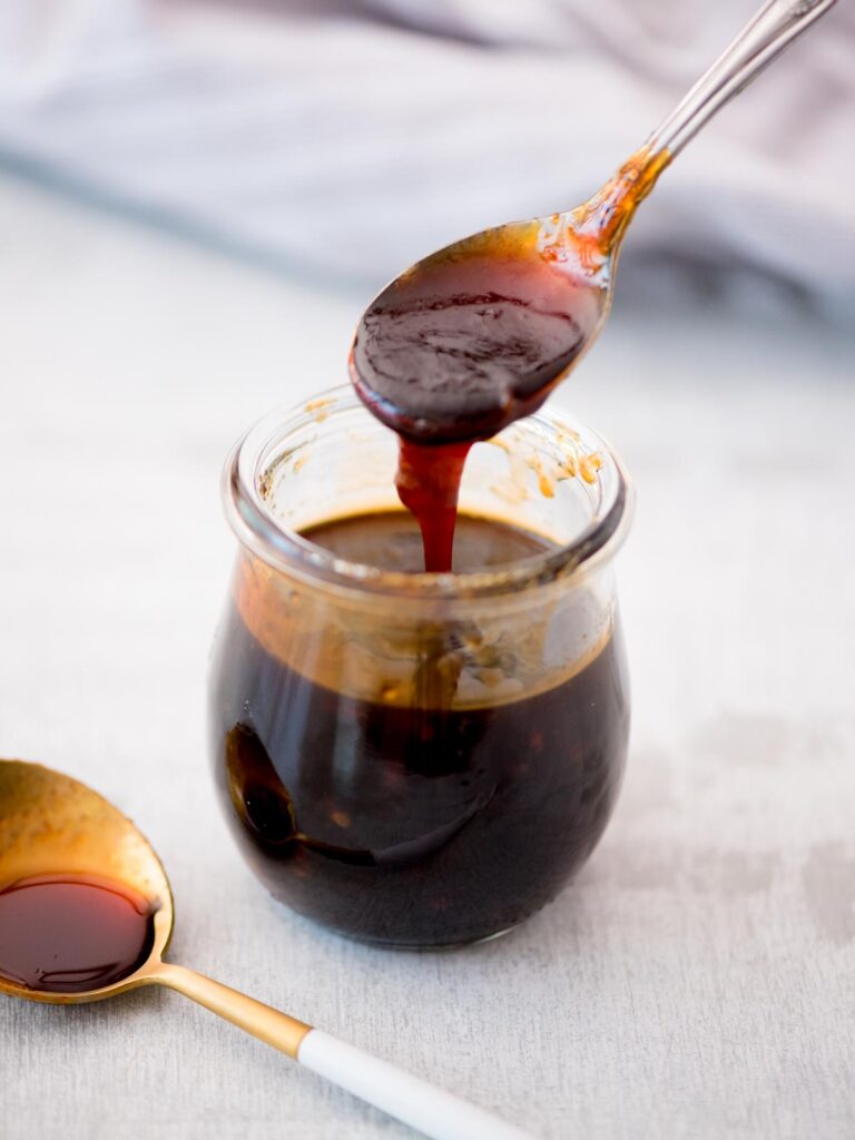 Spoon scooping up honey sriracha sauce.