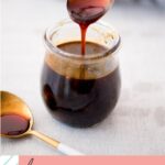 Pinterest image for honey sriracha sauce - small glass jar of honey sriracha sauce with a spoon drizzling sauce into jar.