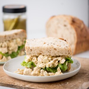 An overflowing tuna salad sandwich on wheat bread.